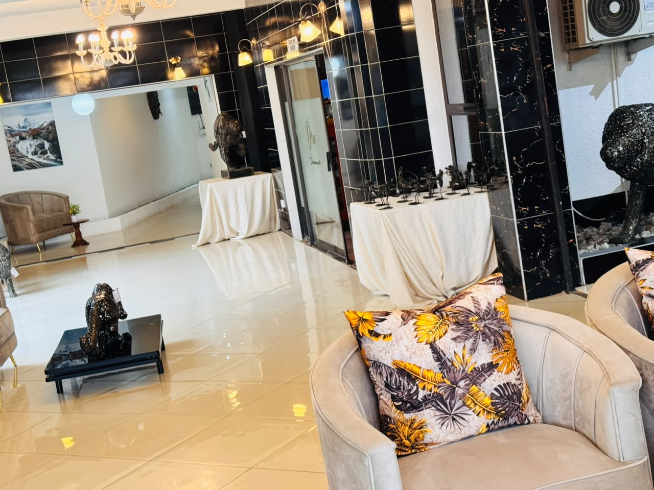 Lobby lounge with velvet armchairs and metal sculptures at DreamWoods, Masvingo