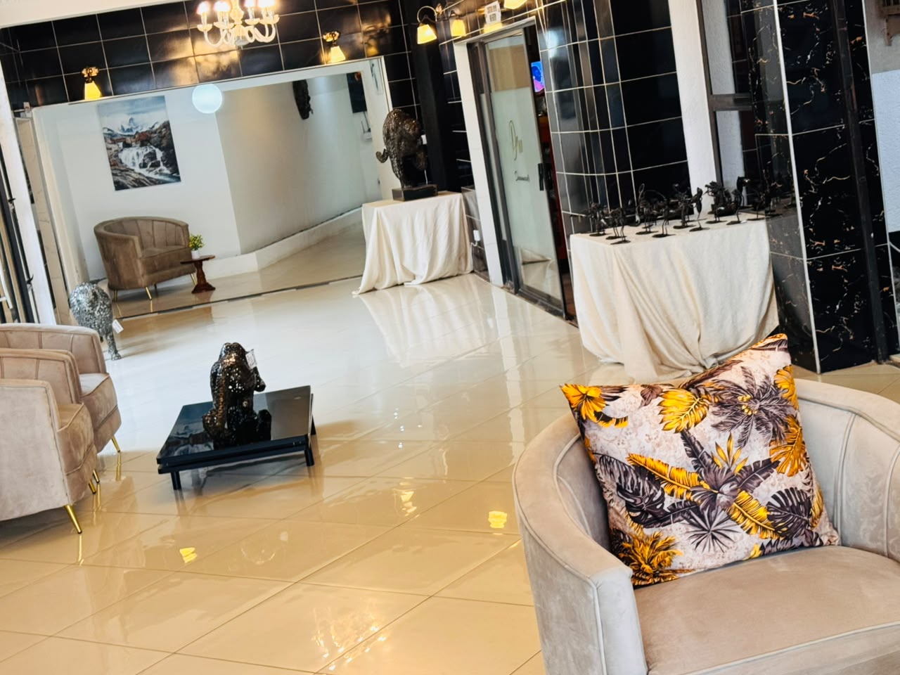 DreamWoods lobby lounge with velvet armchairs, leopard sculptures and polished cream tiles in Masvingo